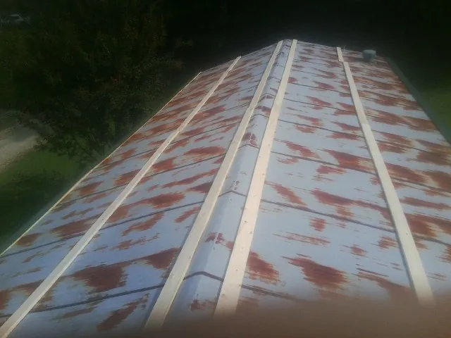 Rusted metal roof panels with new wood purlins before replacement — Storm Damage Roof Repair in Vassar by Roofing Brothers