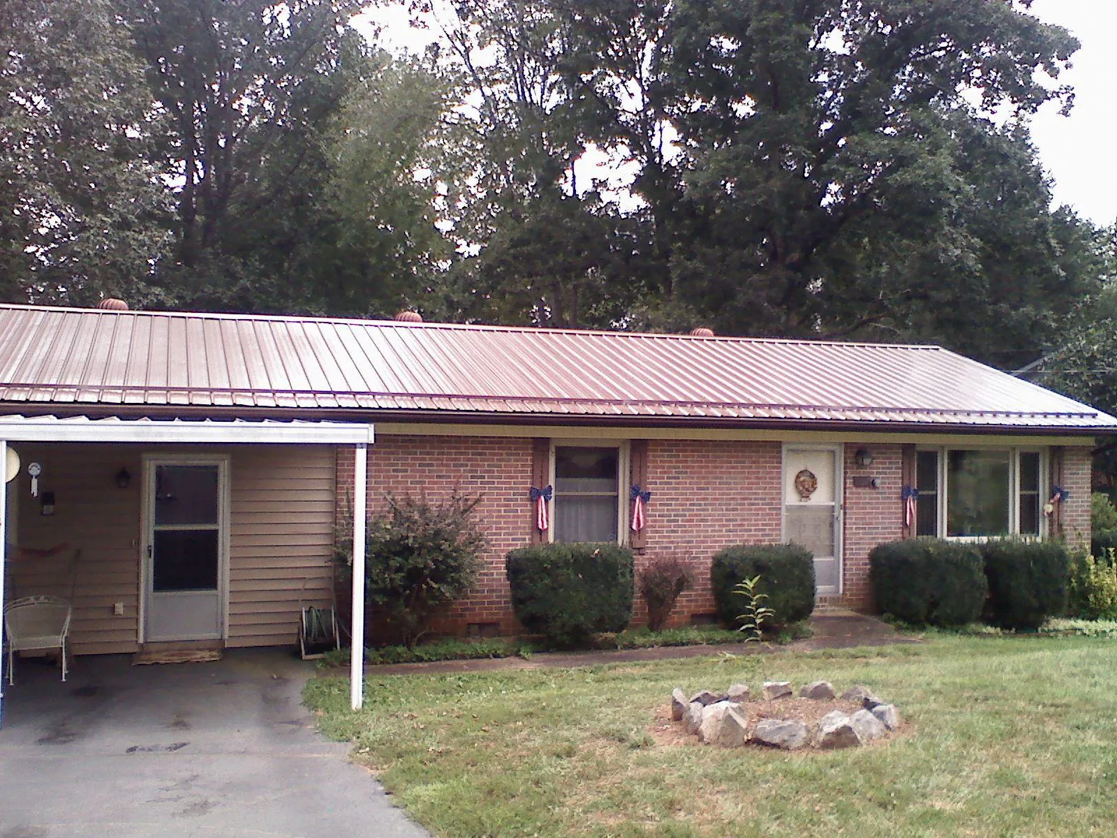 Bronze metal roof and carport on a brick ranch home — Roof Repair work by our crew in Vassar